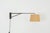 A minimalist Art Deco swing-arm wall lamp dating from the 1920s. The fixture is constructed from brass and features a...