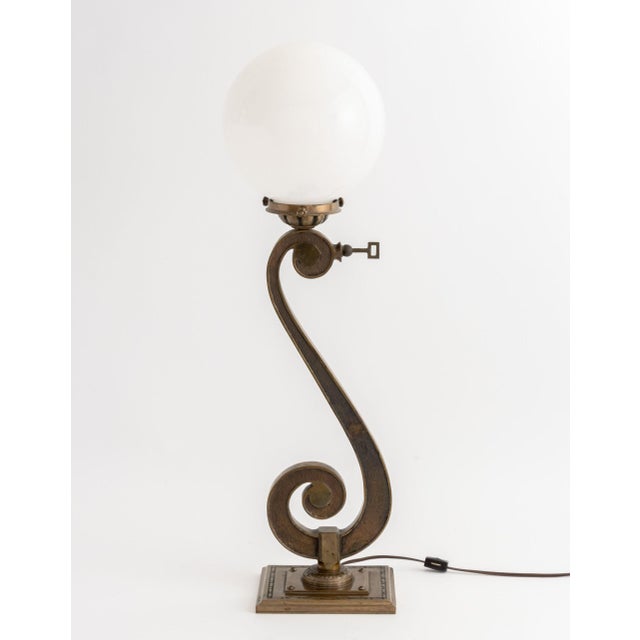 Art Deco Bronze Scroll Form Lamp, with white glass ball form shade on square base. 28.25" H x 9" W x 7.5" D. Provenance:...