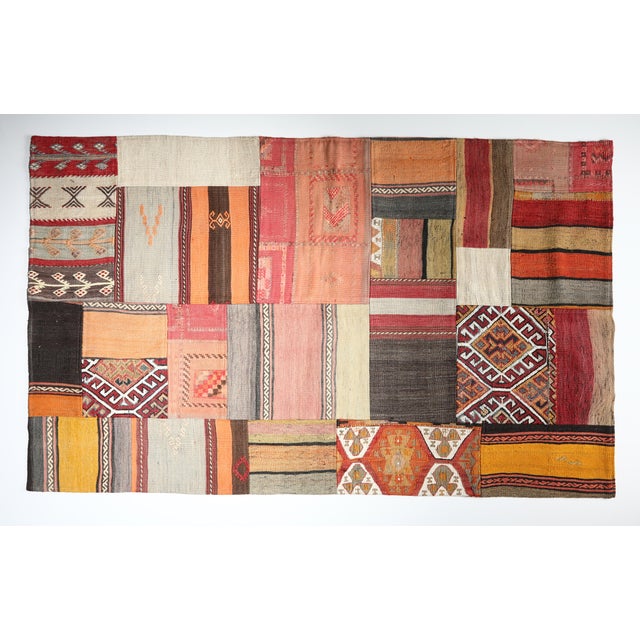 This striking patchwork kilim is a one of a kind composition crafted from handwoven vintage fragments of tribal Turkish...