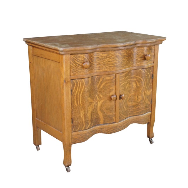 Antique serpentine-front commode or washstand made from quarter-sawn oak, dating back to the late 19th century. Features a...