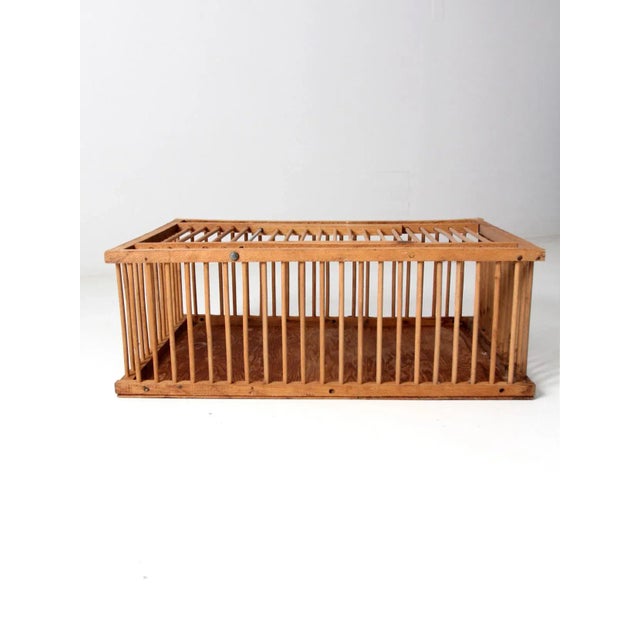 This is a vintage wooden farm crate circa mid 20th century. The wood crate features a spindle bars with a solid wood base....