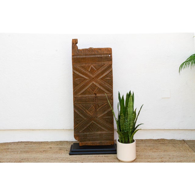 Carved from a single length of hardwood, this door carries the same bold X-motif graphic language documented among the Bwa...