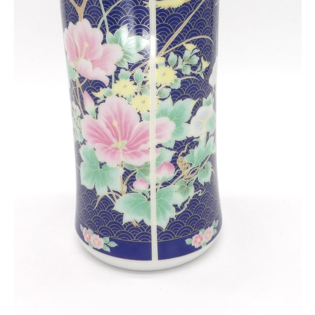 This striking 11" tall Japanese porcelain vase features a dramatic deep cobalt blue ground covered in an all-over gold...