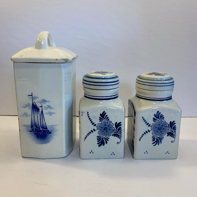 Snag this vintage set of blue and white lidded ceramic coffee canister and delft lidded jars. Both are adorned with Dutch...