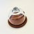 A vintage glass cloche. The top is made of heavy glass with an integrally formed handle sitting on a circular teak base. A...