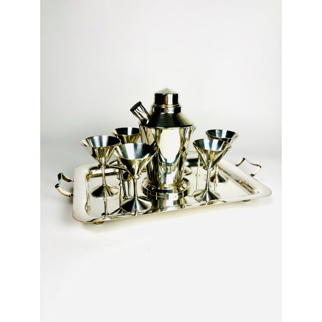A remarkably stylish and highly functional English silver-plated cocktail service dating to circa 1940. This sophisticated...