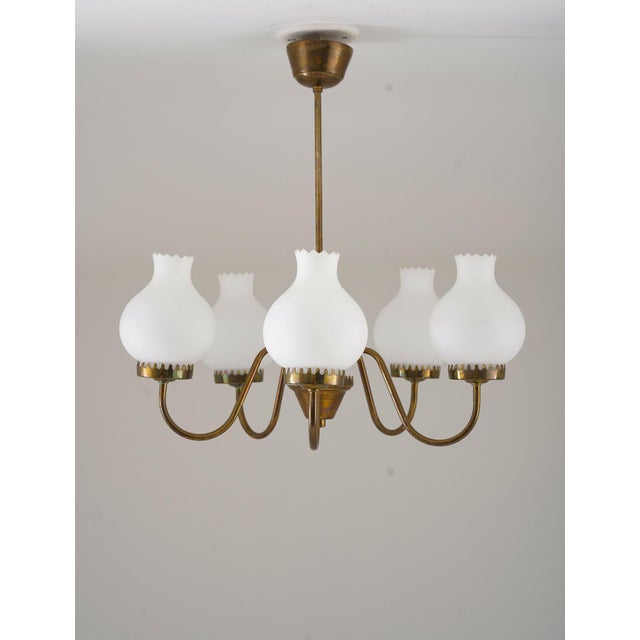 Swedish Modern pendant in brass and frosted opaline glass, manufactured in Sweden, 1950s. This pendant features five light...