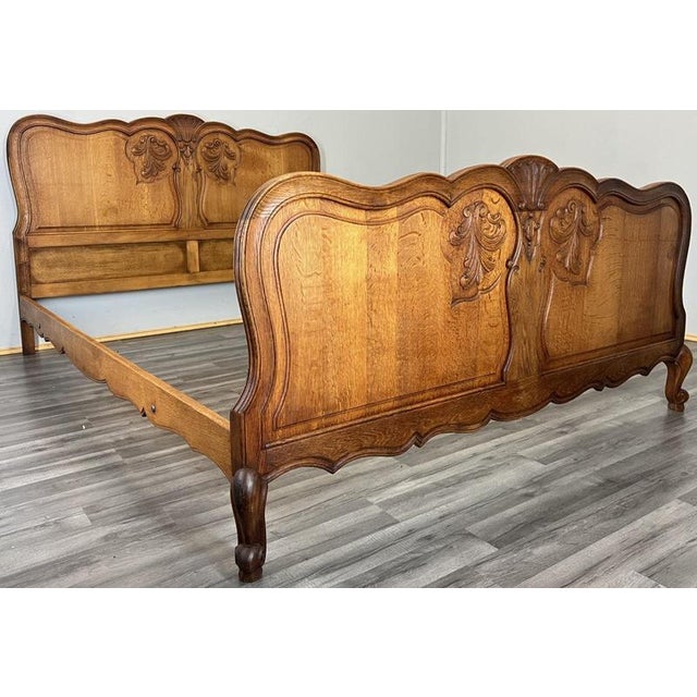This Vintage French Louis king size bed frame showcases beautiful carved flourishes, elegant scalloped shaping and a rich...