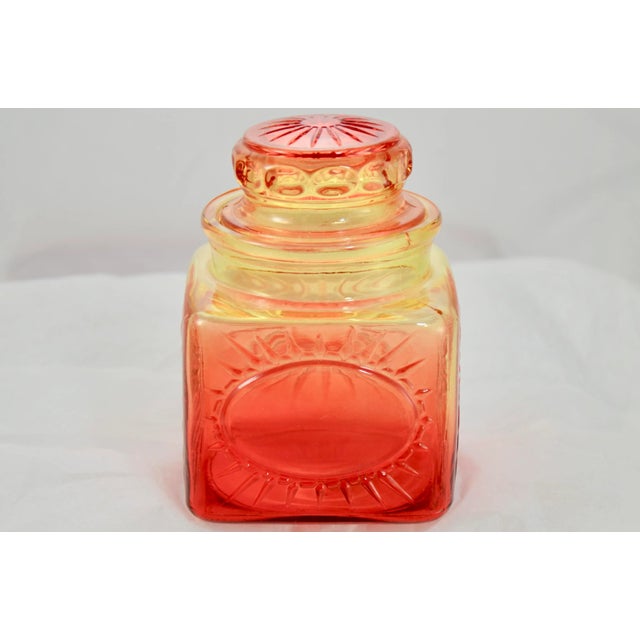 Amber topaz to red ombré flashed glass lidded square jar with star burst pattern on three panels and a smooth oval burst...