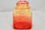 Amber topaz to red ombré flashed glass lidded square jar with star burst pattern on three panels and a smooth oval burst...