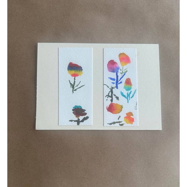 A charming duo of expressive floral studies exploring color blending and organic form. Vibrant washes of red, yellow, and...