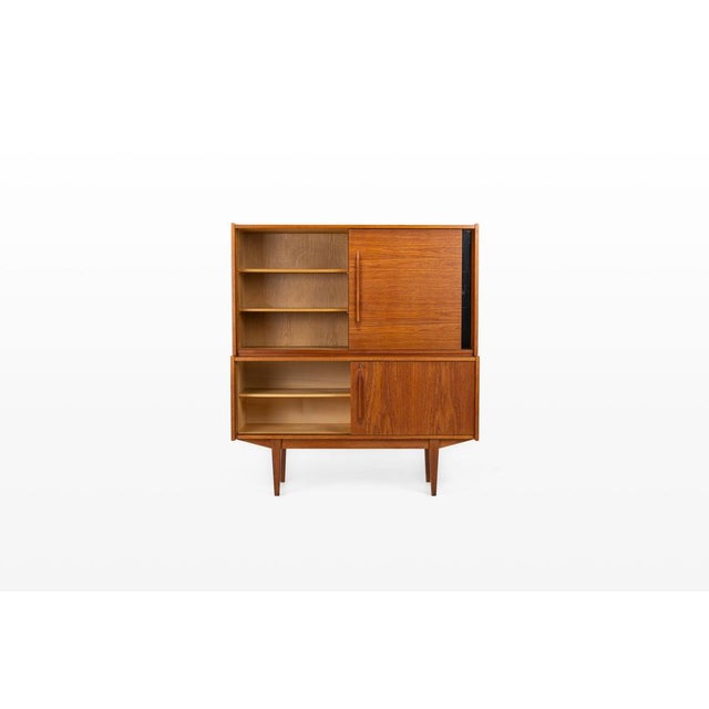 This beautiful vintage highboard from the 1960s is crafted from warm teak wood and combines timeless mid-century design...