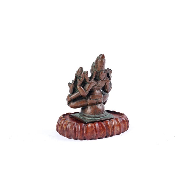 A finely cast South Indian devotional bronze depicting a four-armed, crowned goddess (devi) seated in royal ease on a...