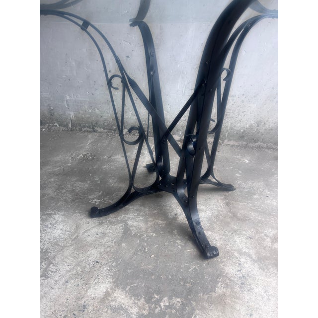 A characterful French Art Deco dining table dating from the 1930s. The table features a round clear glass top resting on a...