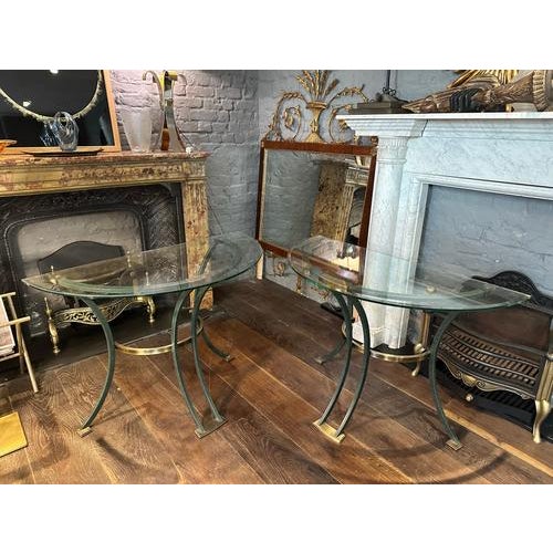 A pair of demi-lune console tables, in brass with bronze verdigris patination and glass tops. By Italian furniture makers...
