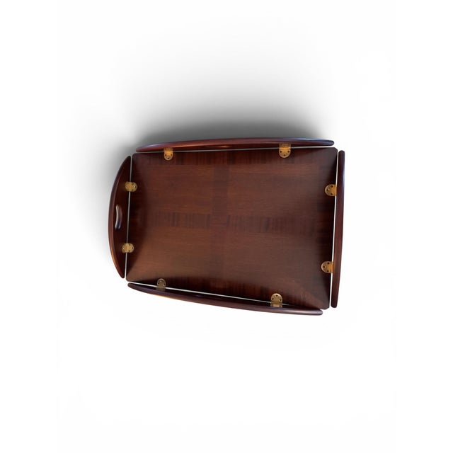 Four curved outer flaps feature built-in cutout handles and are connected to the main tabletop via brass flush-mount...