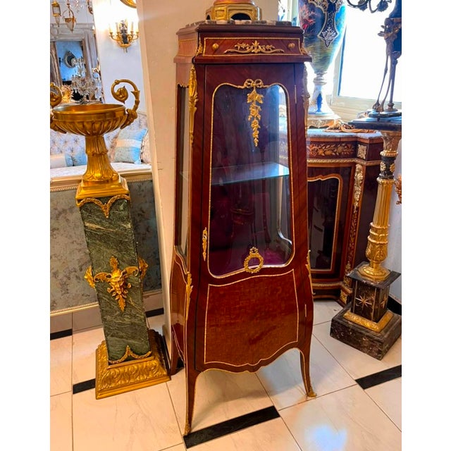 Showcase your treasured collectibles in timeless European elegance with this exquisite French Bombe Curio Cabinet....