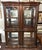 This elegant bombé-front china display cabinet features a richly finished wood frame, gracefully curved glass doors, and...