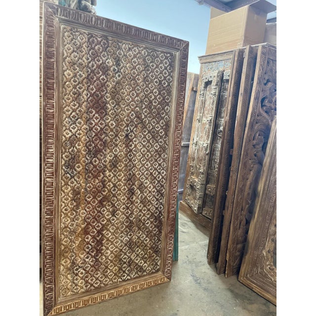 A stunning vintage hand-carved wooden panel, originally crafted as a traditional Indian door, reimagined as a striking...