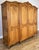 An elegant Vintage French Louis wardrobe with an impressive four-door design, crafted in oak and displaying a warm natural...