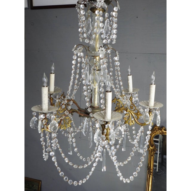 Strands of faceted crystal grace this elegant Country French chandelier. The light fixture is accented with many prisms...
