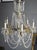 Strands of faceted crystal grace this elegant Country French chandelier. The light fixture is accented with many prisms...
