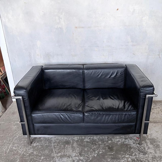 A striking mid-century modern two-seater sofa inspired by the timeless lc2 seating collection designed by le corbusier,...