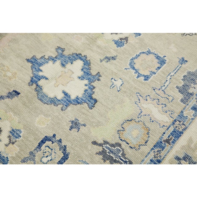 This modern Turkish Oushak rug is a stunning piece of art that has been handwoven using traditional techniques by skilled...