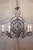 A French wrought-iron clock face chandelier from the 20th century with six scrolling arms and acanthus leaf motifs. This...