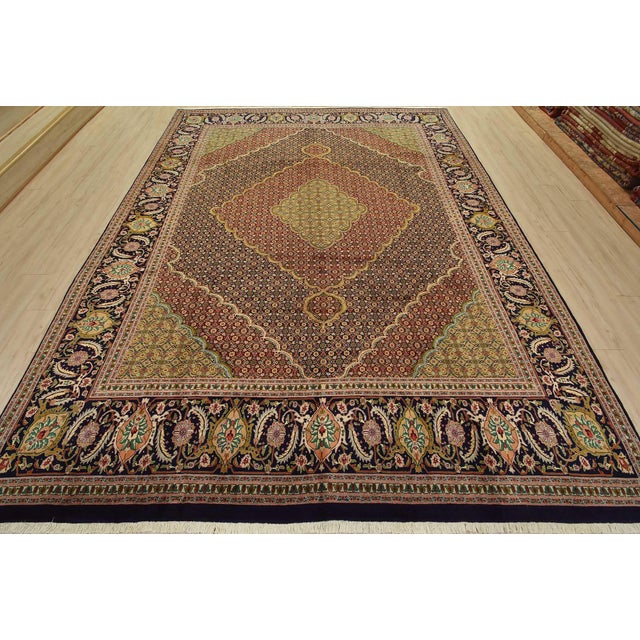 An authentic vintage traditional Tabriz rug hand-knotted with fine wool and natural dyes. This intricately woven rug...