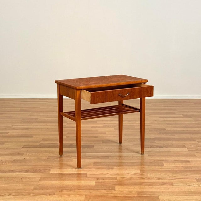 Side table was manufactured in Sweden in the 1950s-60s. It is made of teak veneer and beech on the legs. The table has...