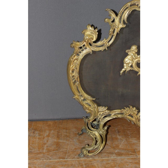 Louis XV style fireplace screen or fire screen in bronze with angel decoration, it rests on four curved feet, circa 1880,...