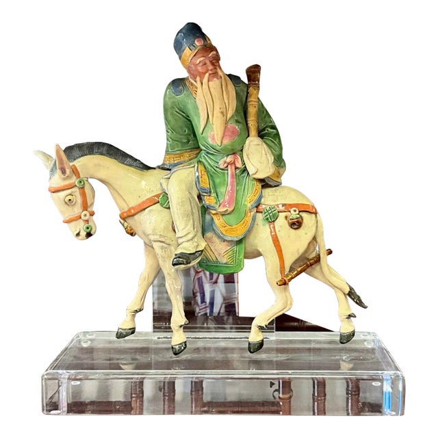 This is an antique Chinese immortal on horseback roof tile that has been mounted on lucite. The composition appears to be...