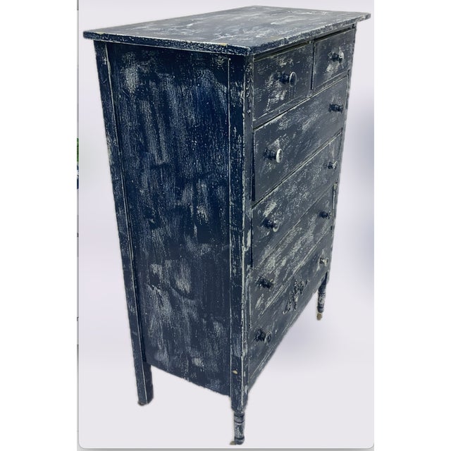 A charming antique pine chest of drawers featuring a beautifully worn, distressed painted finish that reveals layers of...