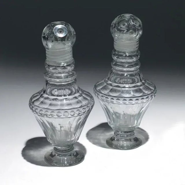 Pair antique 19th c. Anglo Irish cut glass muffineers or sugar casters with screw tops. Measure 6 1/2" tall. Good condition.