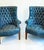 Striking pair of mid-century wingback chairs in original blue leather with deep button tufting, rolled arms and brass...
