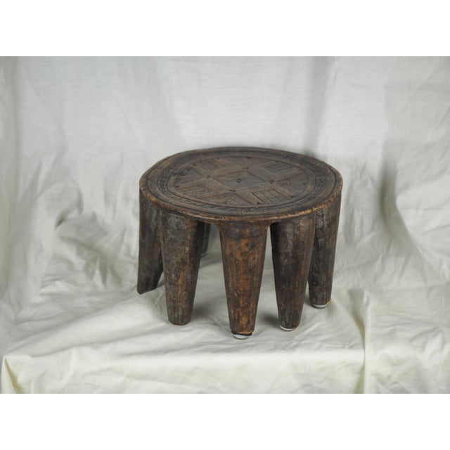 Monoxyle stool with ten conical legs and a circular seat finely decorated with geometric pattern. This prestigious object...