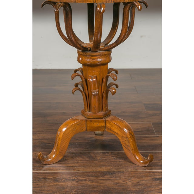 An Austrian Biedermeier period walnut guéridon table from the mid-19th century, with star inlay and scrolling foliage....