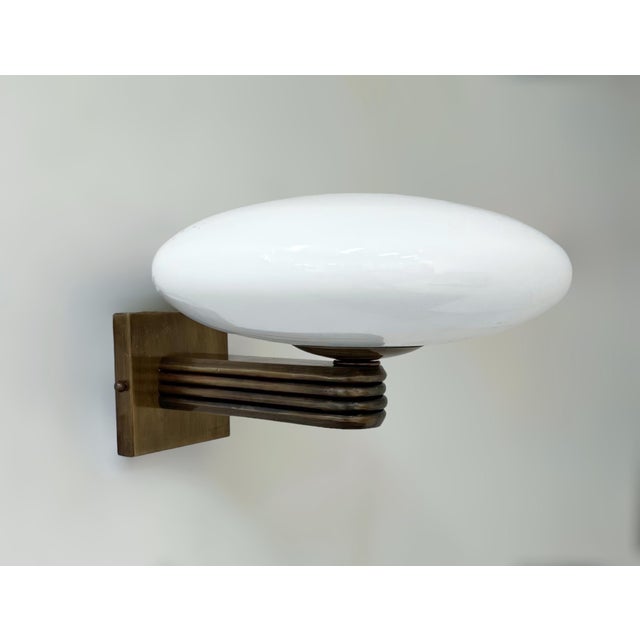 Italian Art Deco style wall light with glossy white Murano glass shade mounted on bronzed finish frame / Designed by Fabio...