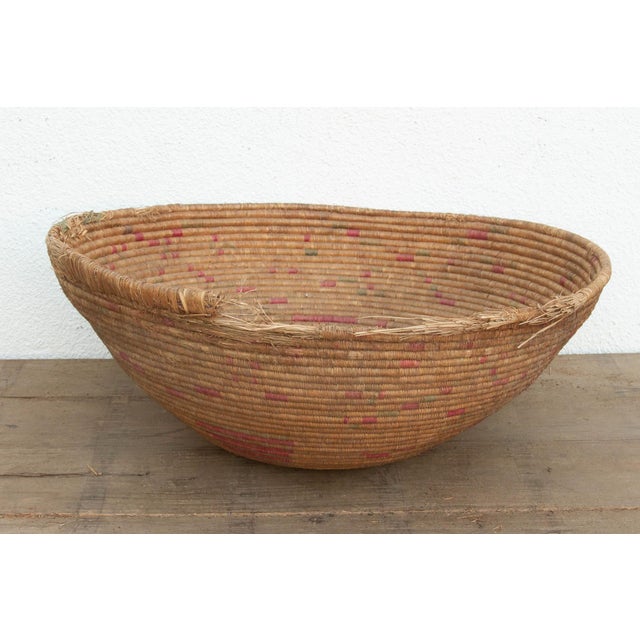 At a commanding 31 inches wide, this oversized nomadic winnowing bowl is a breathtaking artifact of functional tribal...