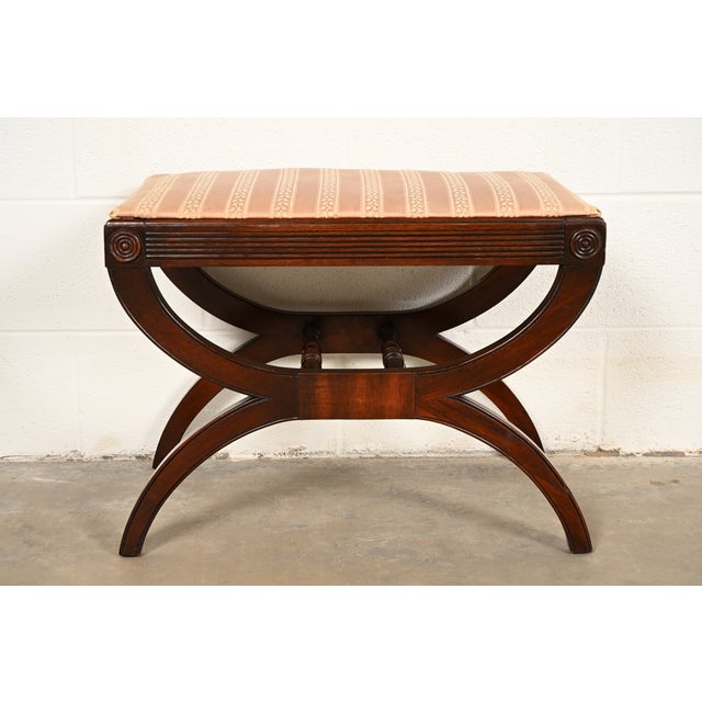 A gorgeous Regency style curule vanity bench, stool, or ottoman By Kindel Furniture USA, Circa 1960s Carved mahogany...