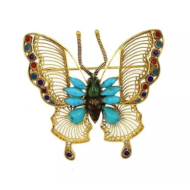 This is a exquisite vintage brooch, it is crafted from 18k yellow gold with a polished fligree design, the body of the...