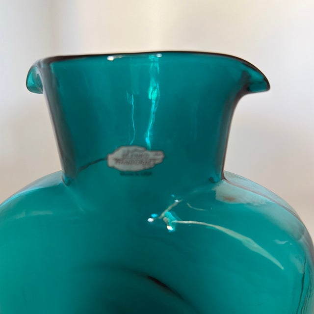 Vintage Blenko Handcraft blown glass pitcher in a striking turquoise-teal color. The sculptural form features a broad...