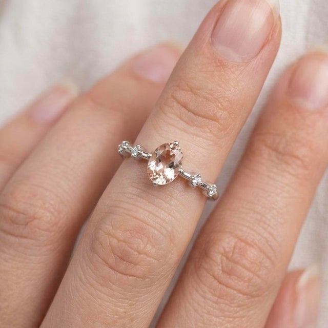 This stunning ring features a soft, blush-toned morganite gemstone, celebrated for its delicate peach-pink hue and...