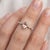 This stunning ring features a soft, blush-toned morganite gemstone, celebrated for its delicate peach-pink hue and...