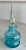 Heavy, blown glass bottle decorated around the rim and base in a beautiful turquoise ribbon of glass. Topped by a...