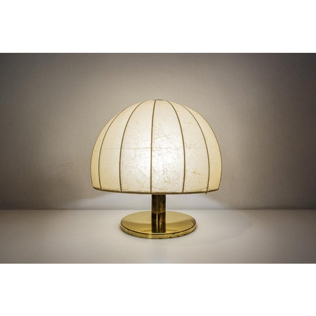 Table lamp with brass frame and cocoon shade. Made in Italy 1970s European Plug (up to 250V).The wiring of this item may...