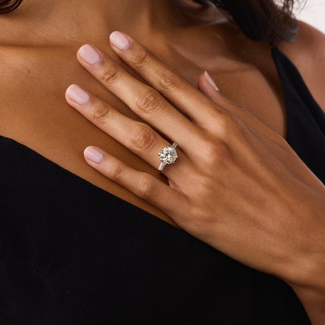 This impressive Mid Century diamond engagement ring is a classic 1960’s design, centered by a GIA-certified round...