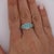 GIA certified Brazilian Paraiba tourmaline and diamond cluster ring in platinum featuring 0.48 carats of greenish blue...