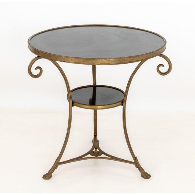 Pair of French Empire Style Marble and Brass Gueridon Tables, each with circular black marble top above three scroll...